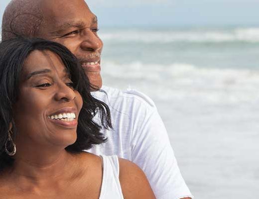 Image of Senior, Black Couple Embracing on the Beach